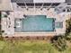 Aerial view of a luxurious pool and spa surrounded by a travertine deck and manicured landscaping at 1636 Rivertowne Country Club Dr, Mount Pleasant, SC 29466