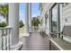 Inviting front porch featuring stately columns, wood floors, and comfortable seating with views of the neighborhood at 1636 Rivertowne Country Club Dr, Mount Pleasant, SC 29466