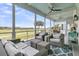 Relaxing screened-in porch with comfortable seating, ceiling fans, and panoramic views of the lush golf course at 1636 Rivertowne Country Club Dr, Mount Pleasant, SC 29466