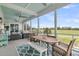 Spacious screened-in porch with an outdoor dining area, ceiling fans, and picturesque golf course views at 1636 Rivertowne Country Club Dr, Mount Pleasant, SC 29466