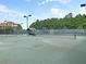 Well-maintained tennis court with surrounding fencing and ample lighting for evening play, set against a backdrop of lush greenery at 1636 Rivertowne Country Club Dr, Mount Pleasant, SC 29466