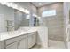 Modern bathroom featuring a double vanity, tiled walk-in shower, and large mirror providing a luxurious spa-like experience at 1641 Adventure Xing, Mount Pleasant, SC 29466