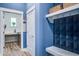 Well-organized laundry room with blue accent wall, overhead shelving, and front load washer and dryer at 1641 Adventure Xing, Mount Pleasant, SC 29466