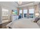 Bright main bedroom with tray ceiling, showcases a wall mounted television, and access to the en-suite bathroom at 1641 Adventure Xing, Mount Pleasant, SC 29466