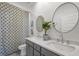 Well-lit bathroom featuring a dual sink vanity with gray cabinetry and round decorative mirrors at 1713 Banning St, Mount Pleasant, SC 29466