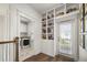 Hallway featuring built-in bookshelves and access to the laundry room and outdoor space at 1713 Banning St, Mount Pleasant, SC 29466