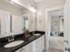 Double vanity in a bathroom featuring dark countertops, white cabinetry, and modern fixtures at 1878 Headquarters Plantation Dr, Johns Island, SC 29455