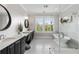 Elegant bathroom featuring dual vanities, a freestanding tub with a glass shower, and black and white checkered tile flooring at 1878 Headquarters Plantation Dr, Johns Island, SC 29455