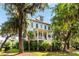 Charming two-story home with a porch, lush landscaping, and inviting curb appeal nestled among mature trees at 1878 Headquarters Plantation Dr, Johns Island, SC 29455