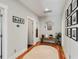 Bright hallway with hardwood floors, a round mirror, and stylish decor, creating an inviting entrance to the home at 1878 Headquarters Plantation Dr, Johns Island, SC 29455