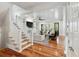 Bright living room with hardwood floors, white couches, and staircase at 1878 Headquarters Plantation Dr, Johns Island, SC 29455