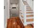Open staircase with wooden treads and white risers next to access to a storage area at 1878 Headquarters Plantation Dr, Johns Island, SC 29455