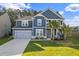 Charming two-story home with blue siding, a well-manicured lawn, and a two-car garage at 202 Buttercup Ln, Summerville, SC 29486