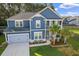 Charming two-story home with blue siding, a gray roof, an attached garage, and lovely landscaped front yard at 202 Buttercup Ln, Summerville, SC 29486