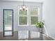 Sunlit living area featuring large windows, modern chandelier, and hardwood-style flooring at 202 Buttercup Ln, Summerville, SC 29486