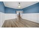 Bright office with blue accent wall, white wainscoting, and wood-look flooring at 202 Buttercup Ln, Summerville, SC 29486