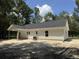 Back exterior with covered porch and HVAC unit, located on a beautiful treed lot at 216 Hill Dr, Summerville, SC 29483