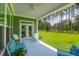 Inviting back porch with ceiling fan and outdoor furniture with a scenic view of a wooded backyard at 217 Quimby Hill Dr, Huger, SC 29450