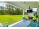 Outdoor living space with a tv, grill, patio seating and scenic backyard with trees and green space at 217 Quimby Hill Dr, Huger, SC 29450