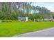 Welcoming entrance sign for Forest Edge community, surrounded by lush green grass and mature trees at 217 Quimby Hill Dr, Huger, SC 29450