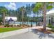 Community pool area with palm trees, patio furniture, and a refreshing swimming pool on a sunny day at 217 Quimby Hill Dr, Huger, SC 29450