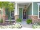Charming front porch with a brown front door, pineapple decor, and views of a palm tree and landscaping at 217 Quimby Hill Dr, Huger, SC 29450