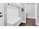 A well-lit mudroom with white bench, storage, and hooks at 217 Quimby Hill Dr, Huger, SC 29450