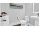Well-lit powder room featuring wood floors, a pedestal sink, and a unique piece of beach-themed artwork at 217 Quimby Hill Dr, Huger, SC 29450