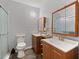 Bathroom featuring double vanity, wood cabinets, shower, toilet, medicine cabinets, and gold fixtures at 2170 Midland Park Rd, North Charleston, SC 29406