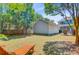 The backyard shows the exterior of the house and the detached garage with a lounge chair and sunny lawn at 2404 Fulford Ct, Mount Pleasant, SC 29466