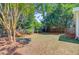 Spacious backyard with mature trees and wood fence; a wooden bench provides a relaxing seating area at 2404 Fulford Ct, Mount Pleasant, SC 29466