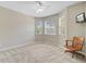 A spacious bedroom with a ceiling fan, plush carpet, and large windows, complemented by a cozy chair at 2404 Fulford Ct, Mount Pleasant, SC 29466