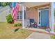 Inviting front porch featuring a rocking chair, patriotic flag, and a classic brick facade at 2404 Fulford Ct, Mount Pleasant, SC 29466