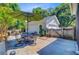 View of the detached garage and a patio with outdoor dining table set with umbrella in the backyard at 2404 Fulford Ct, Mount Pleasant, SC 29466