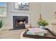 Cozy fireplace featuring a white mantel, with decorative books and plants on a nearby ottoman at 2404 Fulford Ct, Mount Pleasant, SC 29466