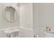 The powder room features a round mirror, a pedestal sink, and elegant wainscoting for a touch of classic style at 2404 Fulford Ct, Mount Pleasant, SC 29466