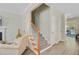 Bright staircase with wood railing and carpeted steps, transitioning to a living area with stylish decor at 2404 Fulford Ct, Mount Pleasant, SC 29466