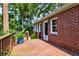 Inviting back porch featuring a wooden deck, brick siding, and landscaping adding to the outdoor charm at 31 Lyttleton Ave, Charleston, SC 29407