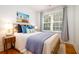 Sun-filled bedroom features wood floors, large window, comfy bed, and beach-themed wall art at 31 Lyttleton Ave, Charleston, SC 29407