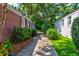 Exterior shot of the home, showing a driveway, brick facade, and lush landscaping around the property at 31 Lyttleton Ave, Charleston, SC 29407