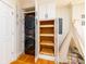 Functional laundry room with stacked washer/dryer and custom built-in white storage cabinets and wooden pull out shelves at 31 Lyttleton Ave, Charleston, SC 29407