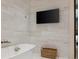 Bright bathroom featuring white tile, soaking tub with handheld shower head and wall-mounted television at 32 Prioleau St # J, Charleston, SC 29401
