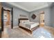 Bedroom features a tray ceiling, wooden floors, wooden framed bed, with doorways to a hallway and bathroom at 32 Prioleau St # J, Charleston, SC 29401