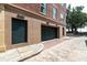 Exterior view of garages with green doors and brick-paved path at 32 Prioleau St # J, Charleston, SC 29401