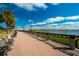 Scenic riverfront walkway featuring benches, palm trees, and water views under a blue sky at 32 Prioleau St # J, Charleston, SC 29401