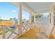 View of a wood balcony with white rocking chairs and decorative white railing overlooking neighborhood at 325 Blowing Fresh Dr, Charleston, SC 29492