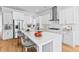 Spacious, modern kitchen with white cabinetry, stainless steel appliances, a large island, and hardwood floors at 325 Blowing Fresh Dr, Charleston, SC 29492