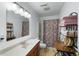Bright bathroom featuring a vanity, mirror, shower with patterned curtain, and convenient shelving for storage at 3347 Walter Drive, Johns Island, SC 29455