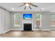 Well lit living room with fireplace, large windows, and luxury vinyl plank floors at 350 Cypress Walk Way, Wando, SC 29492