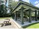 An outdoor pavilion with picnic tables under a covered structure, perfect for community gatherings and shaded relaxation at 350 Cypress Walk Way, Wando, SC 29492